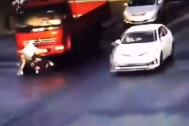 Ciclista chinesa termina embaixo de um caminho em plena avenida e s sofre arranhes