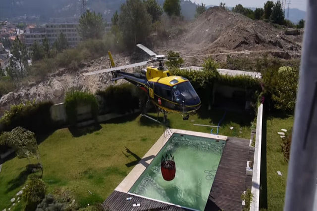 Helicptero dos bombeiros retira gua de uma piscina particular em caso de emergncia
