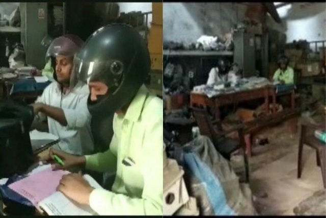 Funcionrios de escritrio indianos usam capacetes de motoqueiro para evitar leses na cabea