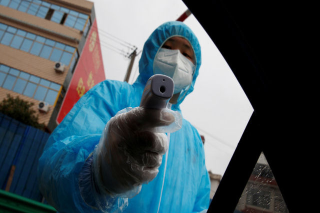 Paramdicos colocam um paciente  fora em uma ambulncia no meio do surto de coronavrus na China