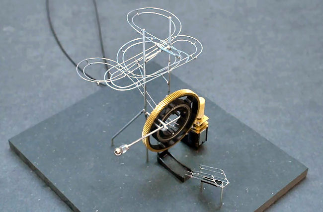 Uma curiosa mini máquina que envia automaticamente uma esfera sobre uma trilha de arame