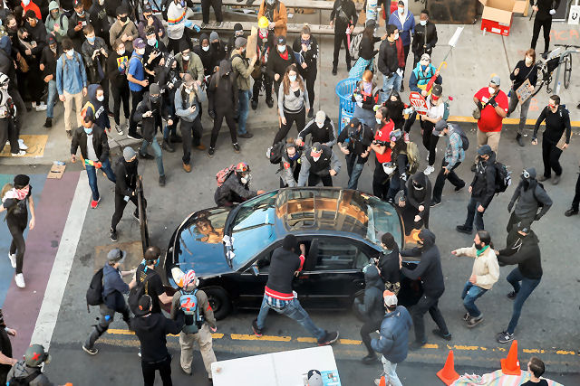 O momento em que uma pessoa conduz um carro em direção a manifestantes e abre fogo em Seattle