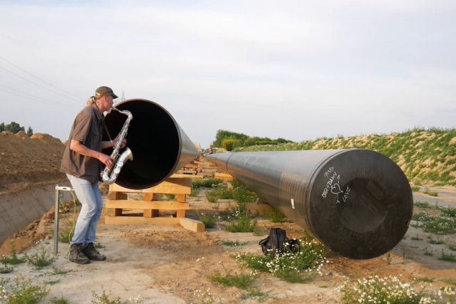 Saxofonista faz dueto com o eco de um tubo gigante de oleoduto