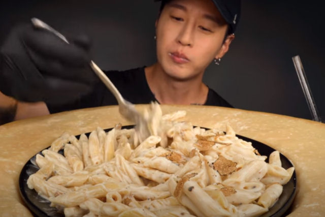 Mukbanger coreano prepara e come macarrão com queijo em enorme roda de parmesão com vídeo ASMR 