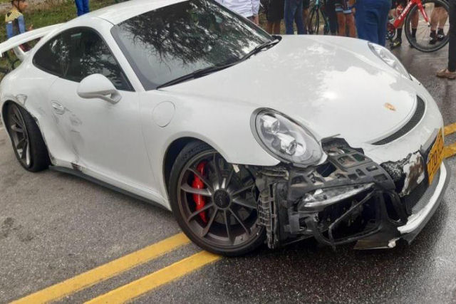 Três Porsches competem em uma movimentada estrada colombiana e um deles se choca contra outros veículos e atropela um ciclista