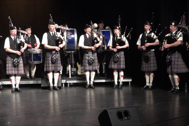 Uma Banda Marcial escocesa na batida de canção do Queen