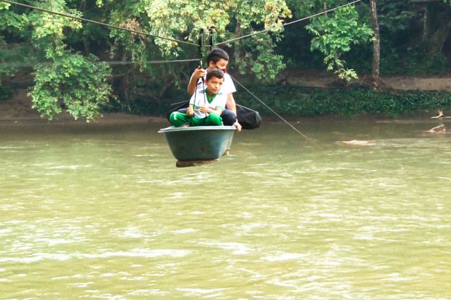 Crianças colombianas arriscam sua vida cruzando um rio em um teleférico caseiro para chegar a escola