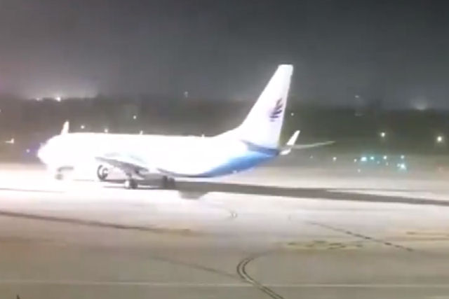 Um vendaval move um avião na pista de um aeroporto na China