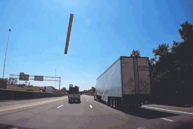 Tábua de madeira sai voando em uma rodovia e atravessa o para-brisas de um carro