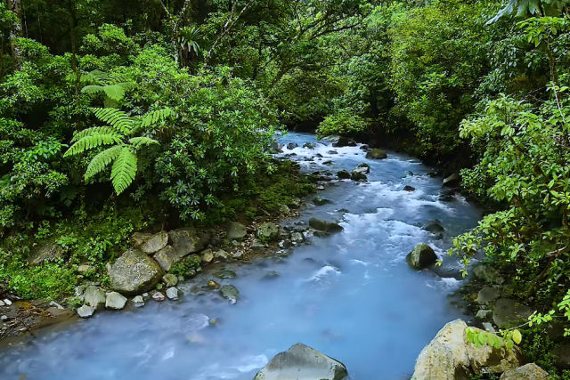 Belas imagens aéreas de uma cachoeira azul turquesa na floresta tropical da Costa Rica