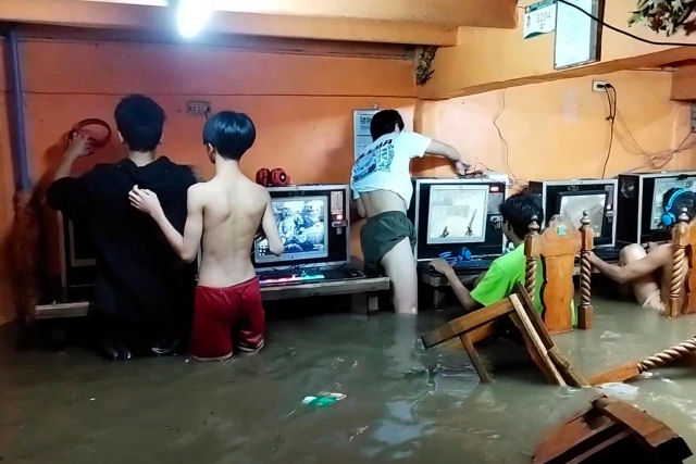 Gamemaníacos continuam jogando na lan house mesmo durante a inundação de um tufão