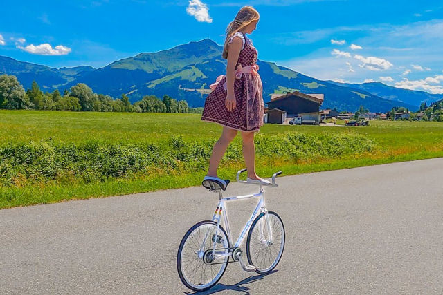 Bela alemã faz belos truques de bike tendo a bela paisagem austríaca como fundo