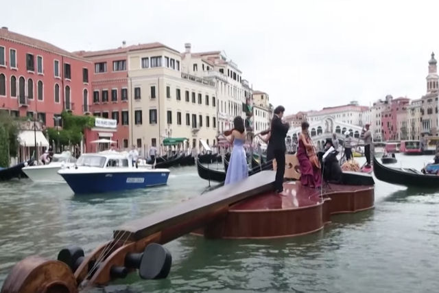 Violino gigante flutua no canal de Veneza com um quarteto de cordas no topo