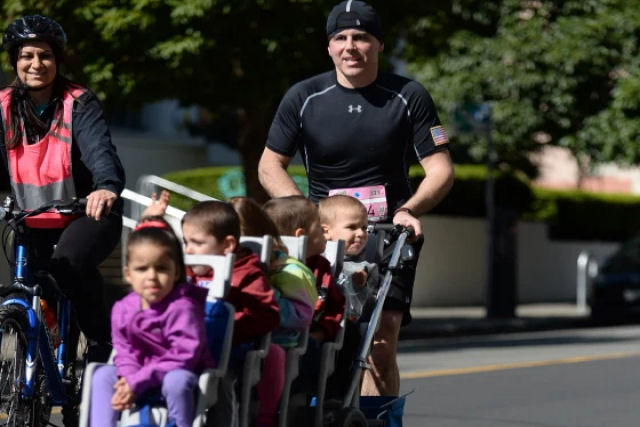 Pai correu meia maratona enquanto empurrava 5 crianças em um carrinho