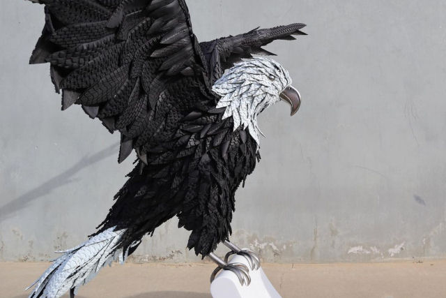 Uma incrível escultura de águia-americana estendida feita de aço, espuma e pneus reciclados