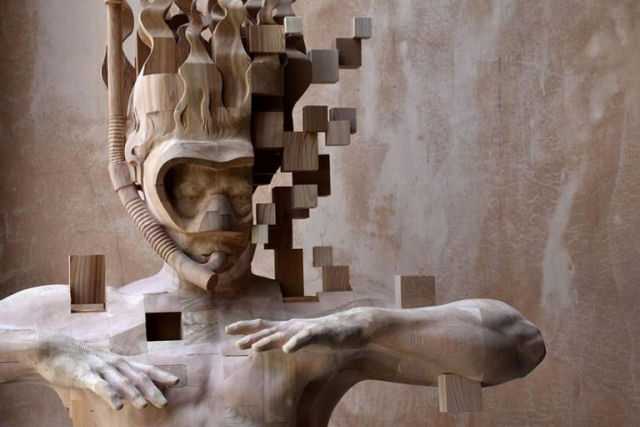 Esculturas figurativas parecem se fragmentar com pixels de madeira