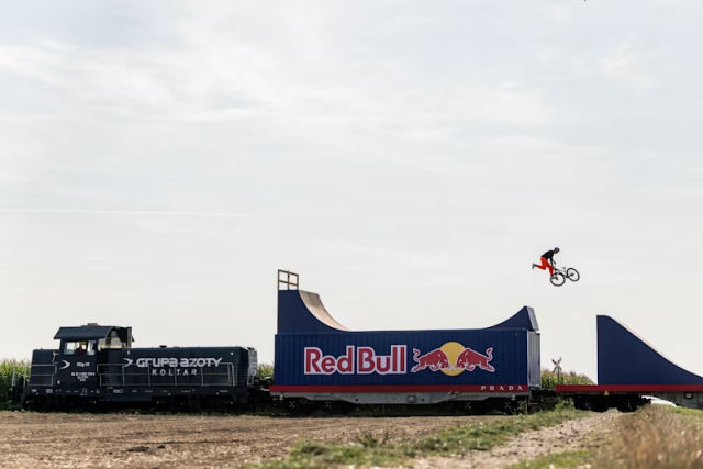 Ciclista Freestyle realiza manobras pedalando em cima de um trem em movimento